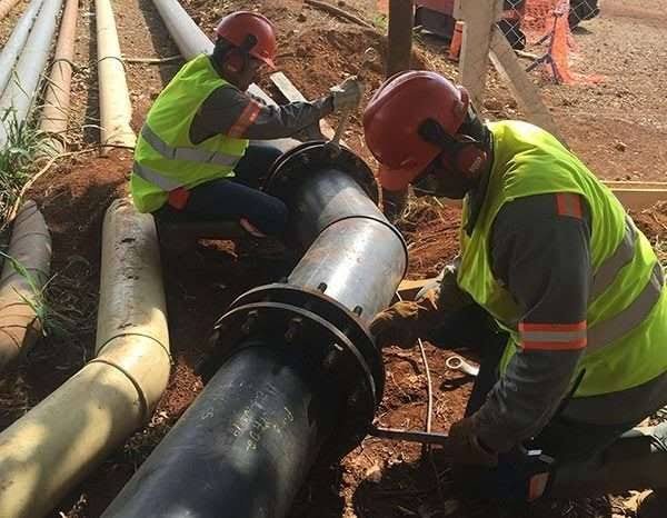 Equipe instalando tubulação industrial